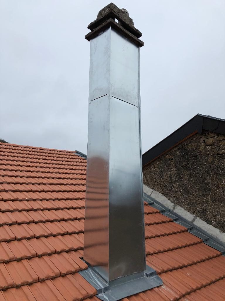 Habillage de cheminée en zinc sur un toit en tuiles